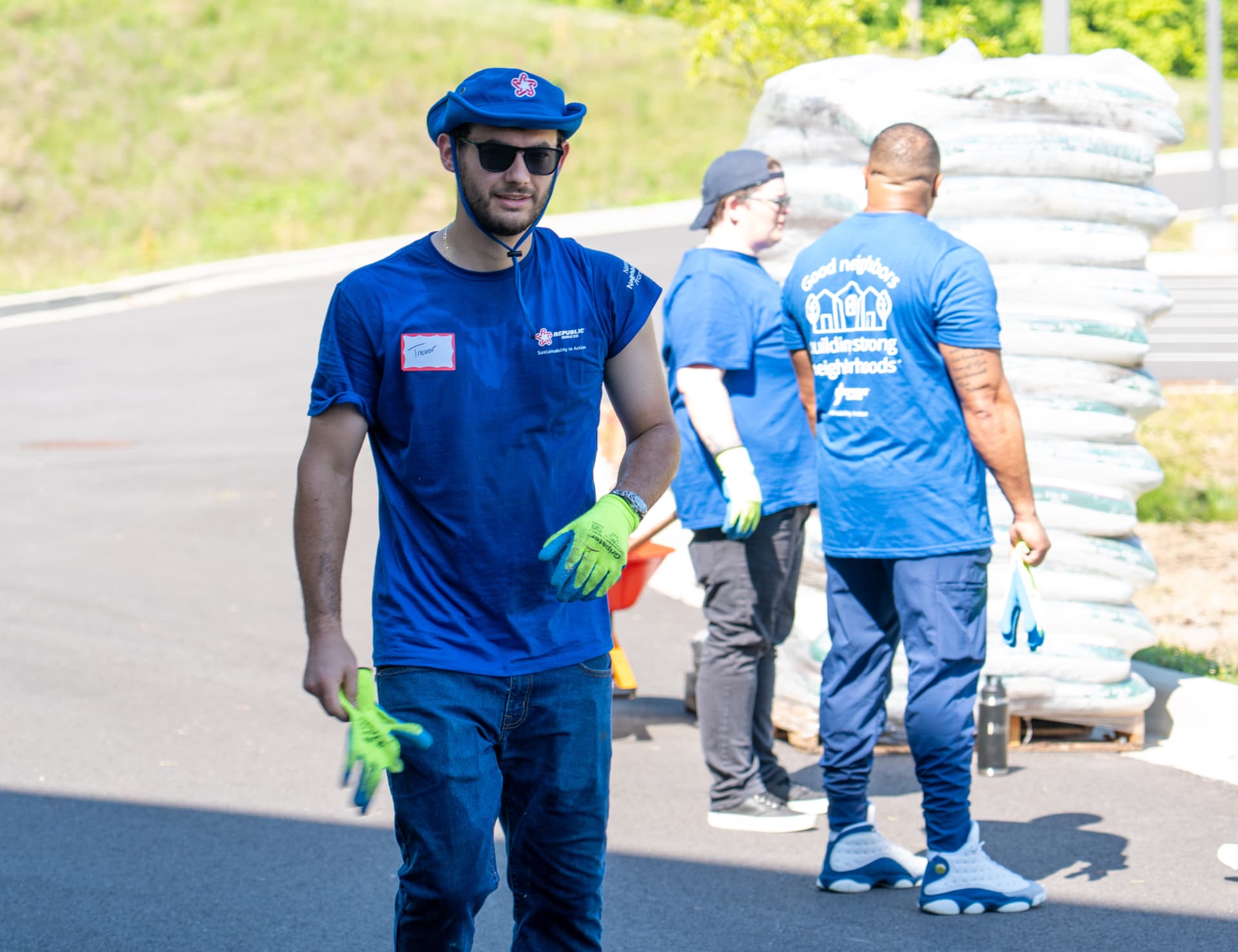 Corporate volunteers in blue team shirts working outdoors during a service day
