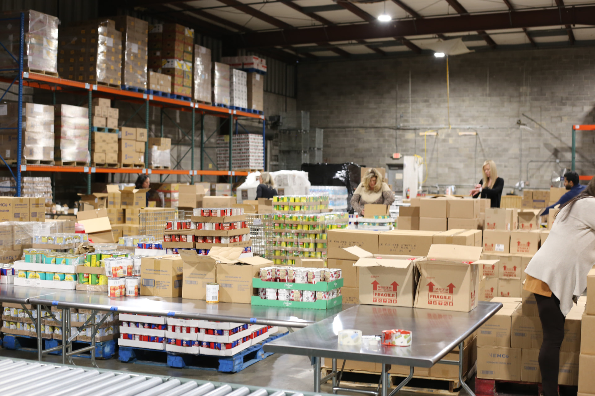 Volunteers sorting canned goods and groceries at the food bank warehouse