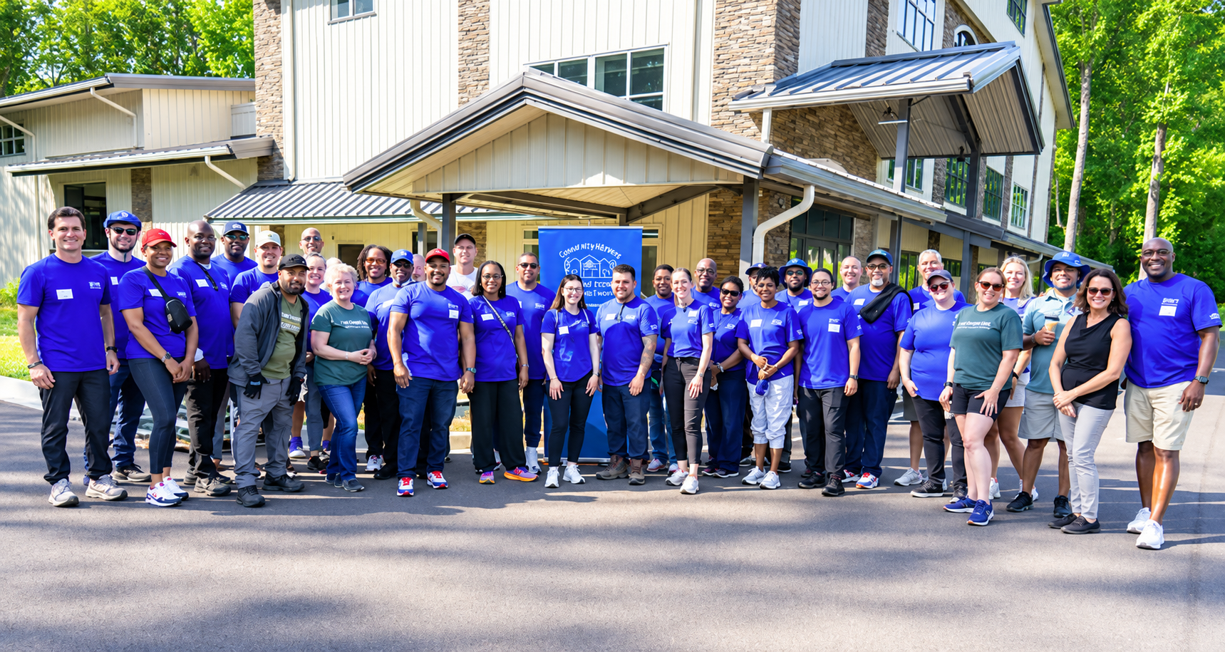 A large corporate volunteer team gathered outside before their service day